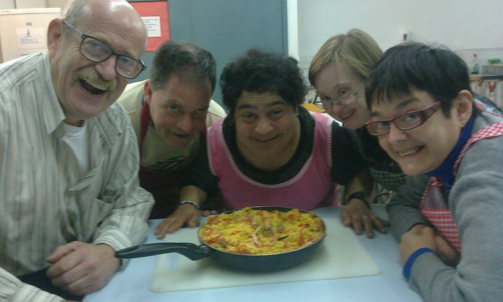 Participants del taller de cuina amb la paella que han cuinat