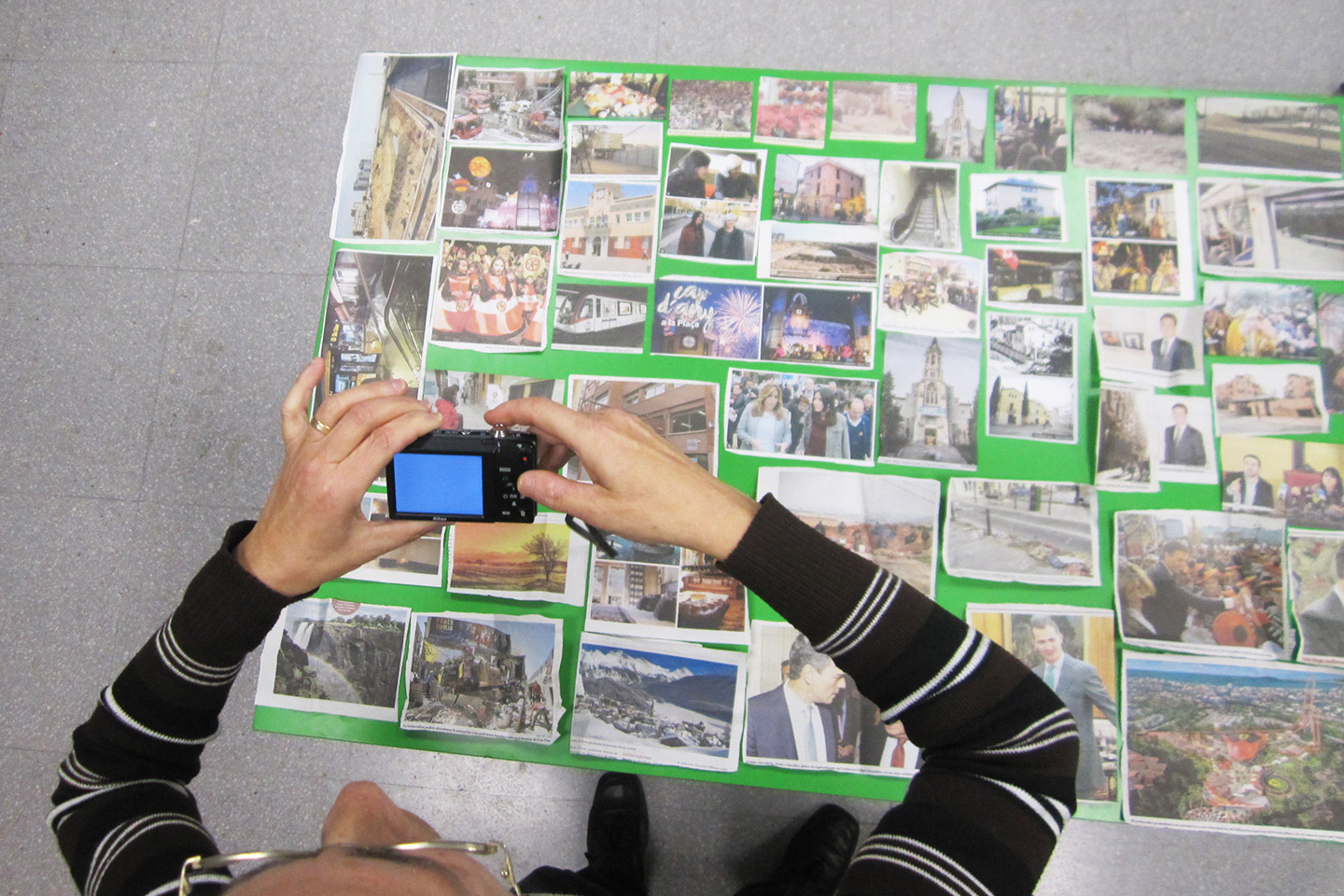 Un participant fotografia un mural fet amb fotos