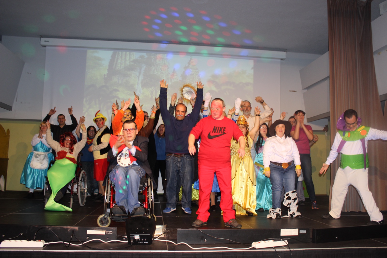 Participants disfressats a l'escenari del festival de Nadal, amb els braços enlaire